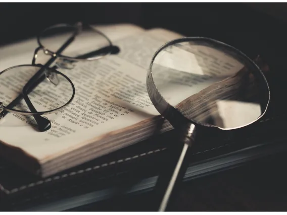 Magnifying glass and glasses on a book